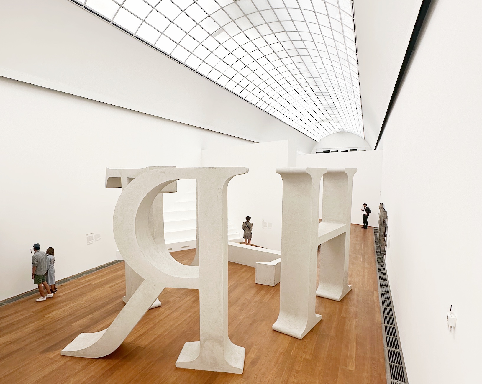 Shilpa Gupta, Truth: five monumental white letters, some reversed, standing in a skylit gallery at Hamburger Bahnhof